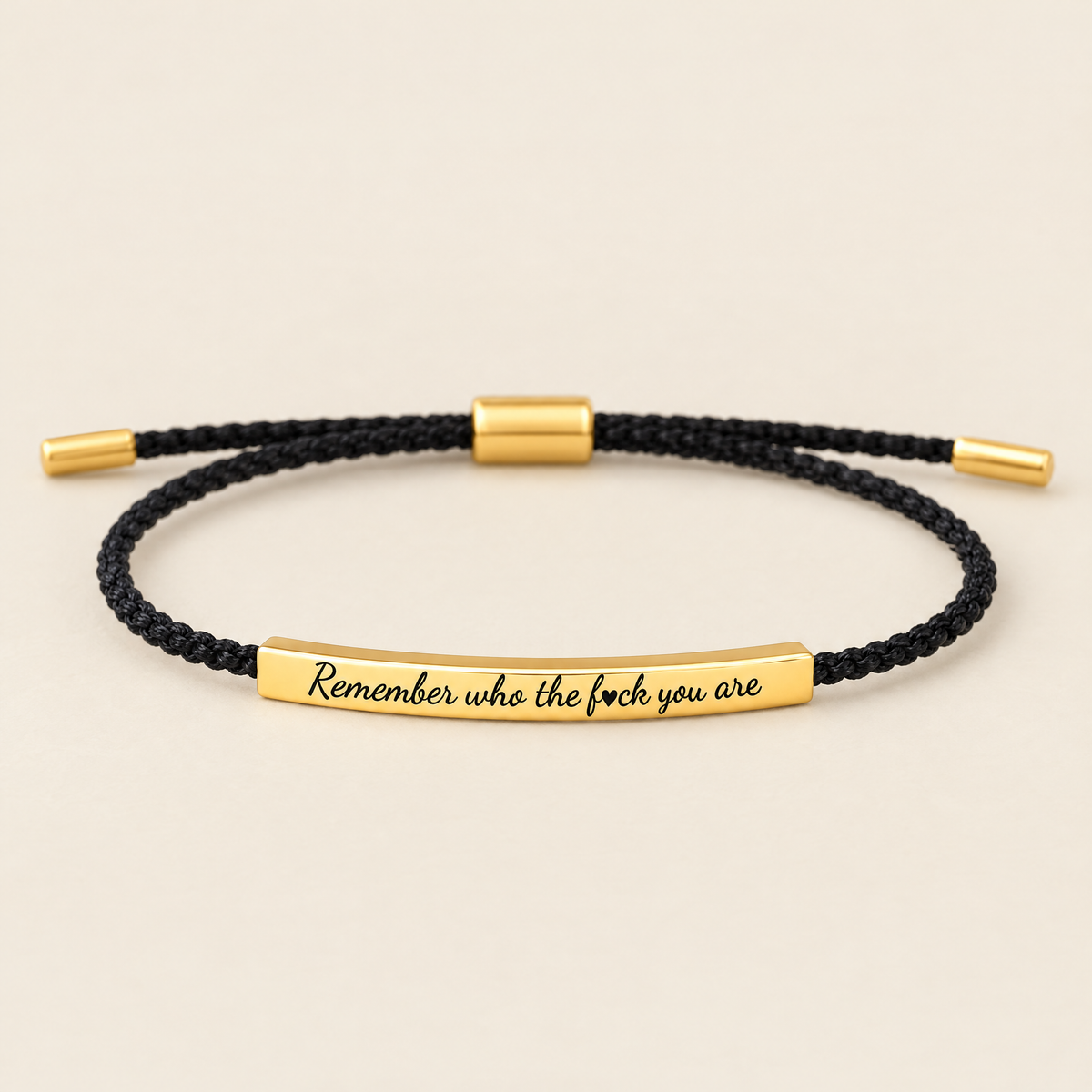 Remember who the f♥ck you are – svart flätat armband med guldplatta