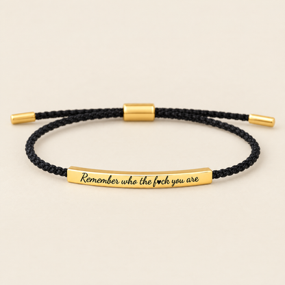 Remember who the f♥ck you are – svart flätat armband med guldplatta