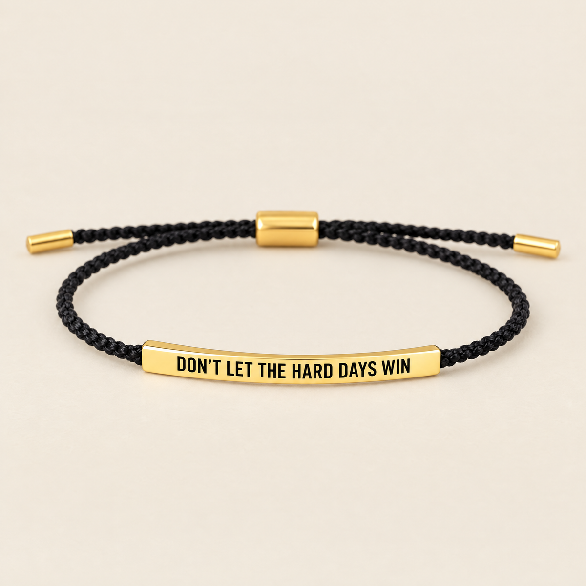 Don't let the hard days win – svart flätat armband med guldplatta